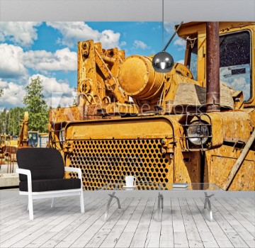 Picture of Old dirty yellow tractor or bulldozer is on the industrial site